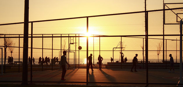 image of basketball players on outdoorcourt at sunset