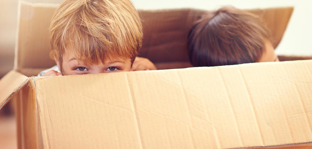 Two children playing in a box